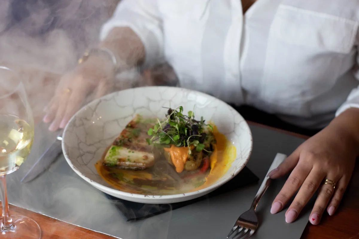 Plato de pescado con copa de vino blanco en Hemisferio Loft, Alcalá de Henares